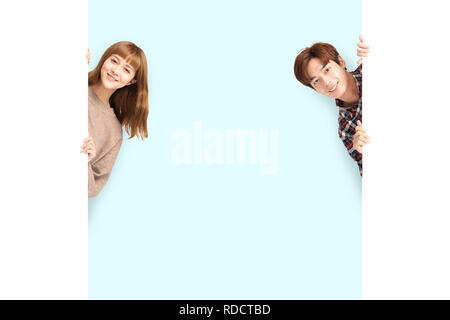 young couple posing  behind blank white board Stock Photo