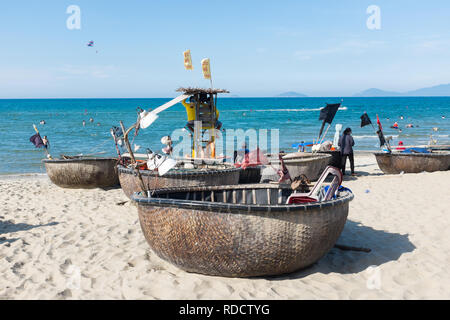 Small fishing boats or coracles sitting on the beach at the Vietnamese city of Hoi An in Quang Nam Province Stock Photo