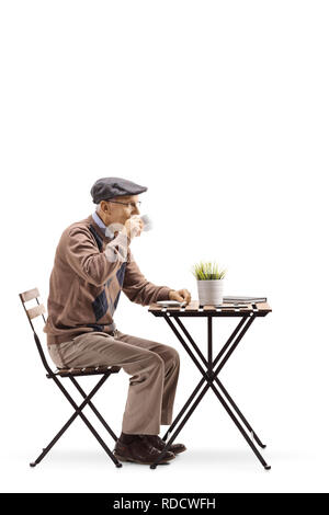 Full length profile shot of a senior man sitting and drinking coffee isolated on white background Stock Photo