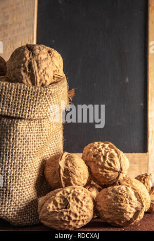 Sack bag with walnut on brown background. Stock Photo