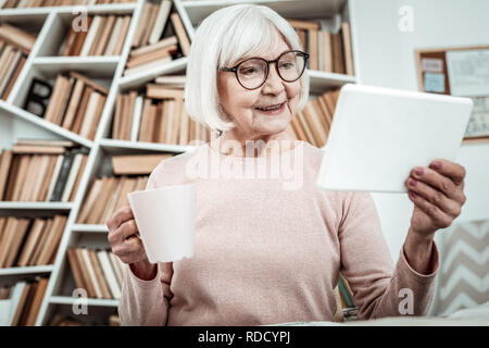 Positive delighted mature student completing home task Stock Photo