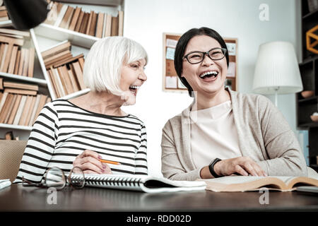 Positive delighted brunette girl laughing at joke Stock Photo