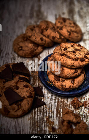 group of tasty cookies next to a bowl on an old wooden board Stock Photo