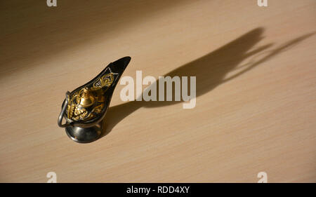 Magic genie lamp with shadows on a light background. Magic Aladdin's genie lamp Stock Photo