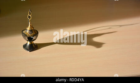 Magic genie lamp with shadows on a light background. Magic Aladdin's genie lamp Stock Photo