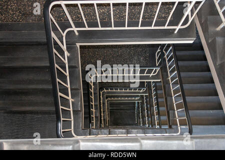 A close up top view of a indoor black and white spiral staircase Stock Photo