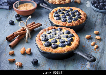 Delicious Blueberry tartlets with vanilla custard cream on rustic wooden background Stock Photo