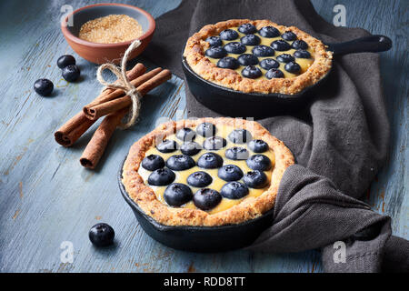 Delicious Blueberry tartlets with vanilla custard cream on grey rustic wooden background Stock Photo