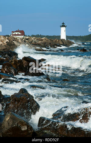 During high tide waves crash against the rocky shoreline by Portsmouth Harbor lighthouse, also referred to as Fort Constitution light. Stock Photo