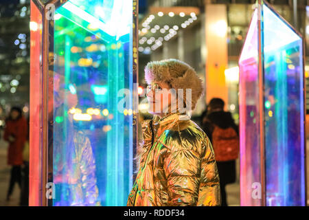 Canary Wharf, London, UK, 17th Jan 2019. Visitors interact and pose with the Prismatica installation of colourful columns in Jubilee Plaza. Many have seized the the cold but dry evening to visit Winter Lights, with crowds and queues building at some installations. Canary Wharf Winter Lights has returned for its fifth year with spectacular light installations and free to view interactive art.  It runs  until Jan 26th. Credit: Imageplotter News and Sports/Alamy Live News Stock Photo