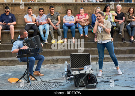 Street musicians giving a spectacular show in Piazza della Signoria in front of a crowd in Florence, Italy. Stock Photo