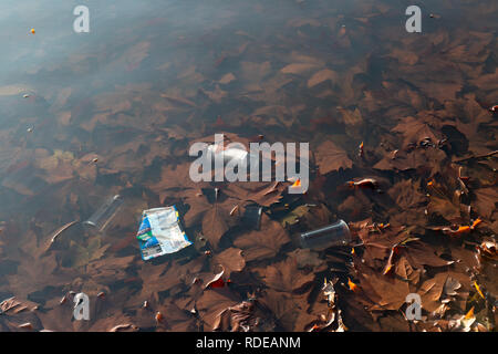 Discarded trash in a pond in Clapham Common, London, UK Stock Photo