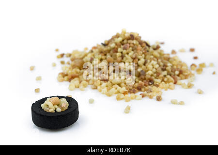 Heap of Frankincense resin and charcoal disc isolated on the white background Stock Photo