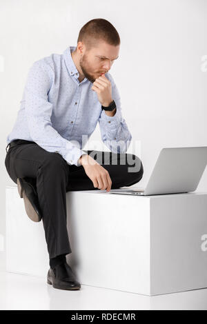 young handsome man in shirt and tie using laptop Stock Photo