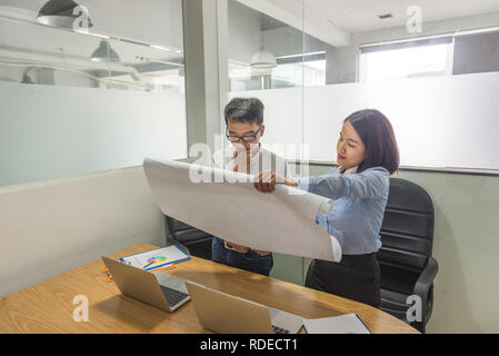 Young Asian manager reading reports of employees Stock Photo