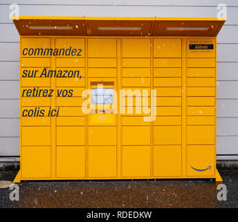 LYON, FRANCE - FEB 4, 2017: Snowing in front view of Amazon Locker orange delivery parcel package locker - self-service parcel delivery offered by online retailer Amazon.com Stock Photo