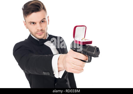 male killer in black suit aiming with gun with proposal ring, isolated on white Stock Photo
