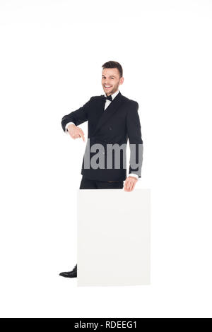 cheerful elegant man in black suit pointing at empty board isolated on white Stock Photo