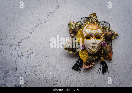Decorative harlequin mask against a white wall background Stock Photo