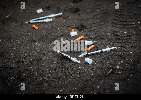 Isolated dropped insuline injections on the ground in the dirt Stock Photo