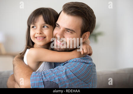 Hopeful single dad embracing kid daughter looking into bright fu Stock Photo