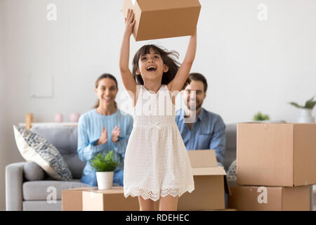 Happy kid girl holding box having fun enjoying moving day  Stock Photo