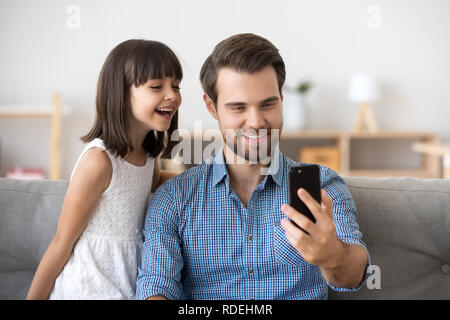 Happy dad taking selfie with kid on smartphone at home Stock Photo