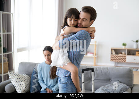 Sad little girl upset by father leaving embracing dad Stock Photo