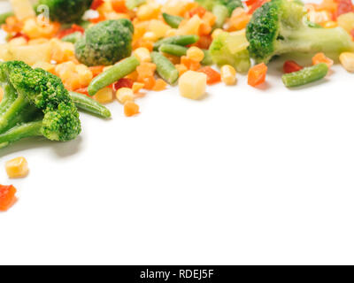 Frozen vegetables assorted isolated on white with clipping path. Frosen vegetables with ice Isolated one edge. Frozen mix vegetables with copy space for text. Stock Photo