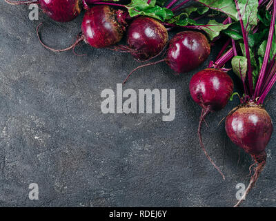 Beet, beetroot bunch on dark stone or concrete background. Fresh ripe beetroot with leaf on dark table. Copy space. Top view or flat lay Stock Photo
