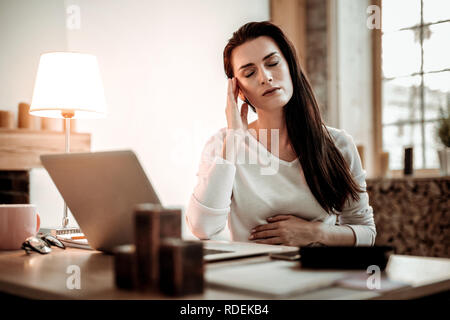 Pleasant nice young woman touching her head Stock Photo