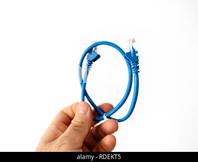 Man holding in hand against white background blue Ethernet internet cable to connect to fast-speed gigabit internet network Stock Photo