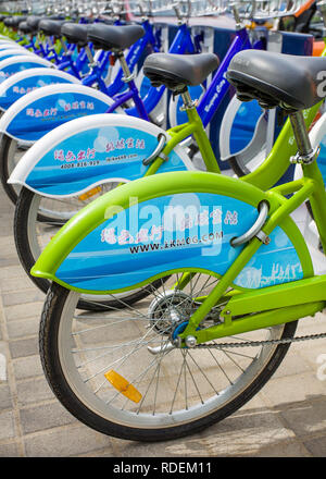 Bicycles parked in public bicycle sharing station. Bicycle sharing allow to hire on a very short term basis, it’s a popular transport mode. Stock Photo