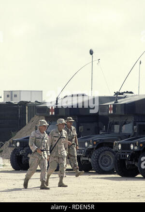 12th October 1993 U.S. Army soldiers walk past parked Humvee ambulance variants at the 46th Combat Support Hospital, inside the UNOSOM headquarters compound in Mogadishu, Somalia. Stock Photo