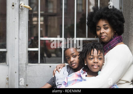 African American mother with kids sit outside smiling