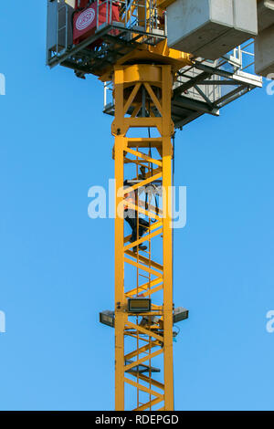 A frame tower crane, seen on almost every major construction site throughout the world. These machines are built to lift heavy loads efficiently. Stock Photo