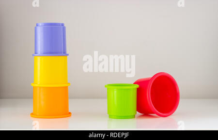 Toy stacking cups in bright colours on a white background with copy space. Stock Photo