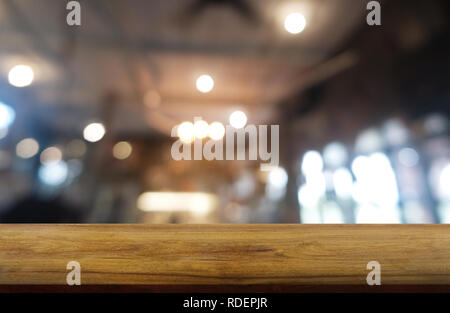 Empty dark wooden table in front of abstract blurred background of restaurant, cafe and coffee shop interior. can be used for display or montage your  Stock Photo