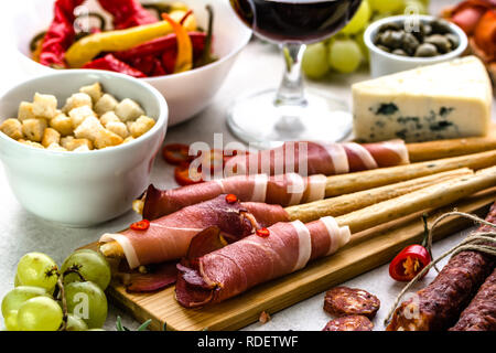 Bread with prosciutto or grissini stick with ham, traditional italian antipasti, food platter Stock Photo