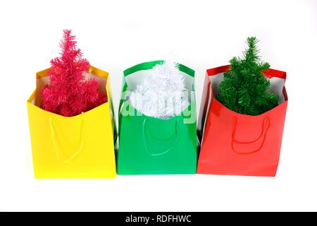 Colorful gift bags with small plastic Christmas trees, Christmas shopping Stock Photo