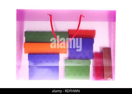 Clear plastic bag filled with colorful paper gift boxes Stock Photo