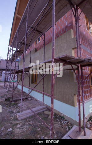 green color insulation being put on the wall Stock Photo