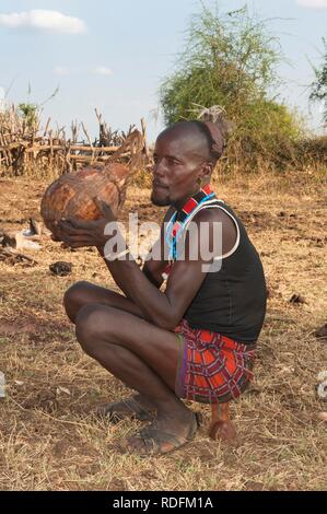 Hamar man drinking sorghum beer from a calabash, Omo river valley, Southern Ethiopia, Africa Stock Photo