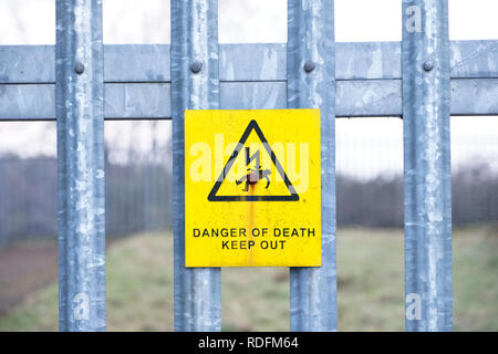 Danger of death safety sign on wooden telegraph post against blue sky Stock Photo