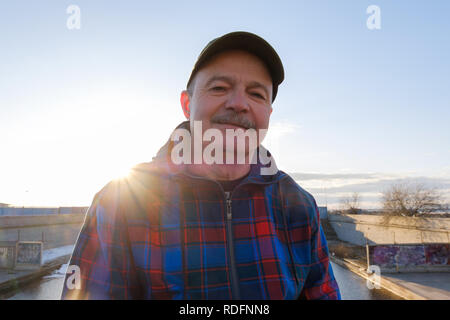 Senior man with mustache looking at camera against gblue sky and smiling. Stock Photo