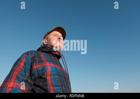 Senior man with mustache looking at camera against gblue sky and smiling. Stock Photo