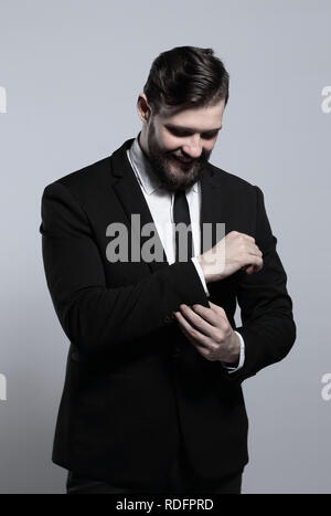 serious businessman adjusting his cuff link on the sleeve of the shirt Stock Photo