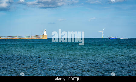 Blyth Lighthouse, the pier and a wind turbine on the North Sea Coast, seen on South Beach in Blyth, England, UK Stock Photo