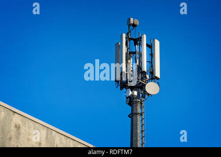 Close up of telecommunications tower mast against blue sky Stock Photo