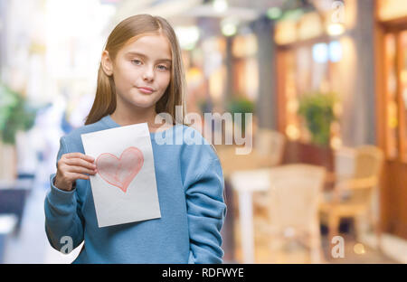 Young beautiful girl giving mother father day card with red heart over isolated background with a confident expression on smart face thinking serious Stock Photo